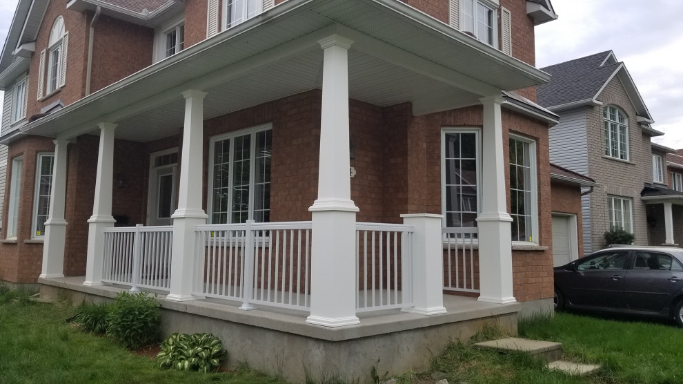 Inspiration for a large modern front metal railing veranda in Ottawa with with columns, concrete slabs and a roof extension.