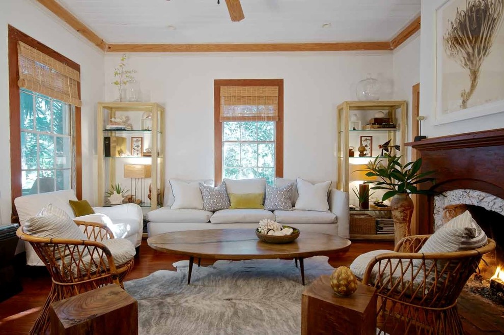 Photo of a mid-sized beach style open concept family room in Jacksonville with a library, white walls, medium hardwood floors, a standard fireplace, a wood fireplace surround and no tv.