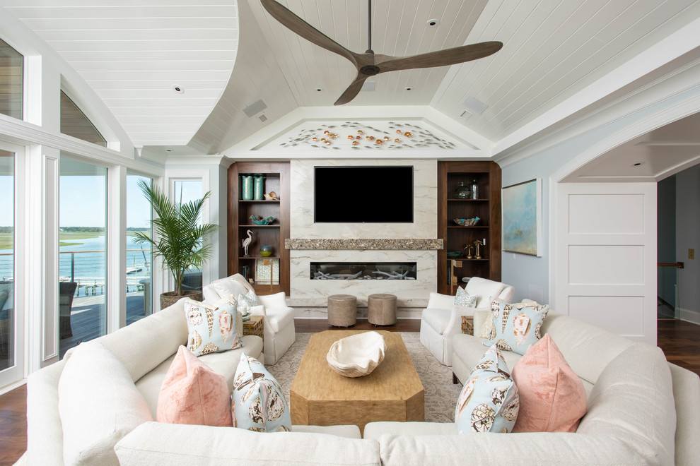 This is an example of a beach style family room in Other with blue walls, a ribbon fireplace, a stone fireplace surround and a wall-mounted tv.