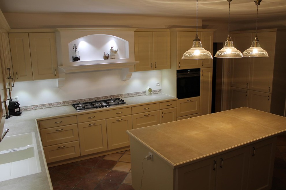 Design ideas for a large traditional l-shaped open plan kitchen in Nice with a double-bowl sink, recessed-panel cabinets, beige cabinets, tile benchtops, multi-coloured splashback, travertine splashback, stainless steel appliances, terra-cotta floors, with island and multi-coloured floor.