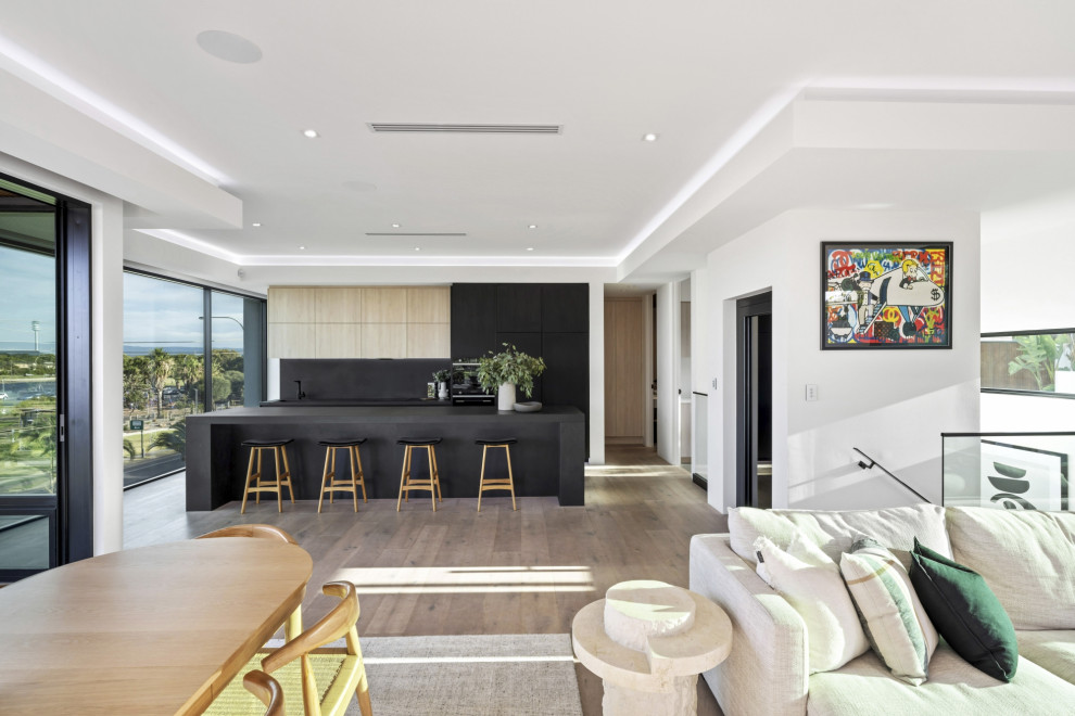 This is an example of a large contemporary open concept living room in Adelaide with light hardwood floors.