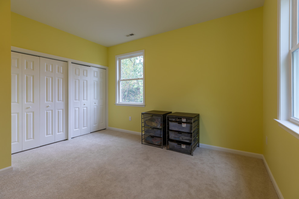 Immagine di una grande camera degli ospiti minimalista con pareti gialle, moquette, nessun camino e pavimento beige