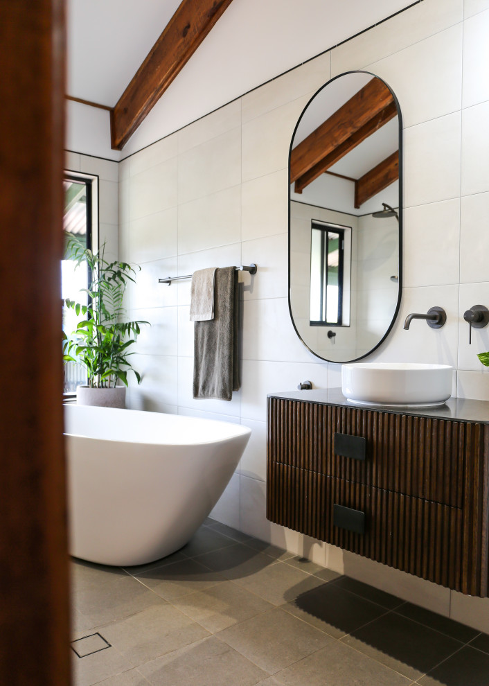 Idéer för att renovera ett stort funkis grön grönt en-suite badrum, med möbel-liknande, skåp i mörkt trä, ett fristående badkar, en öppen dusch, en toalettstol med hel cisternkåpa, beige kakel, keramikplattor, vita väggar, klinkergolv i keramik, ett fristående handfat, bänkskiva i täljsten, flerfärgat golv och med dusch som är öppen