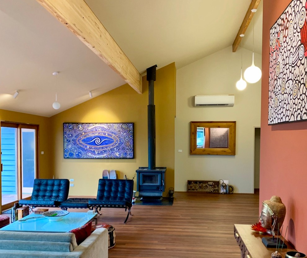 Photo of an eclectic living room in Sydney with a corner fireplace and a wood fireplace surround.