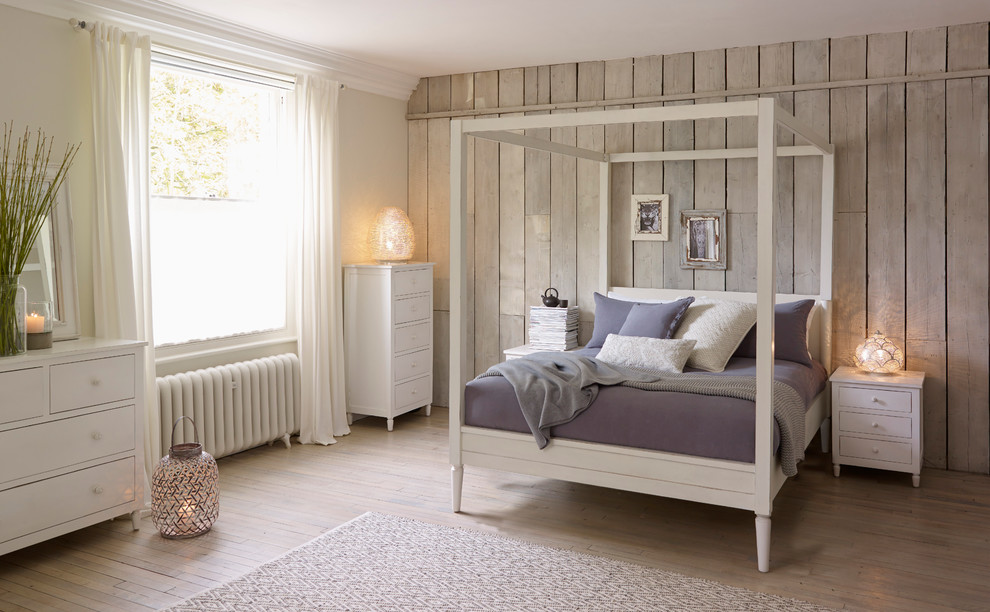 Inspiration for a large traditional master bedroom in London with grey walls and light hardwood floors.