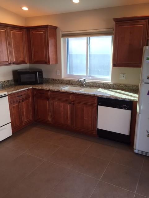 Inspiration for a small transitional l-shaped ceramic tile eat-in kitchen remodel in Phoenix with an undermount sink, raised-panel cabinets, medium tone wood cabinets, granite countertops, white appliances and no island