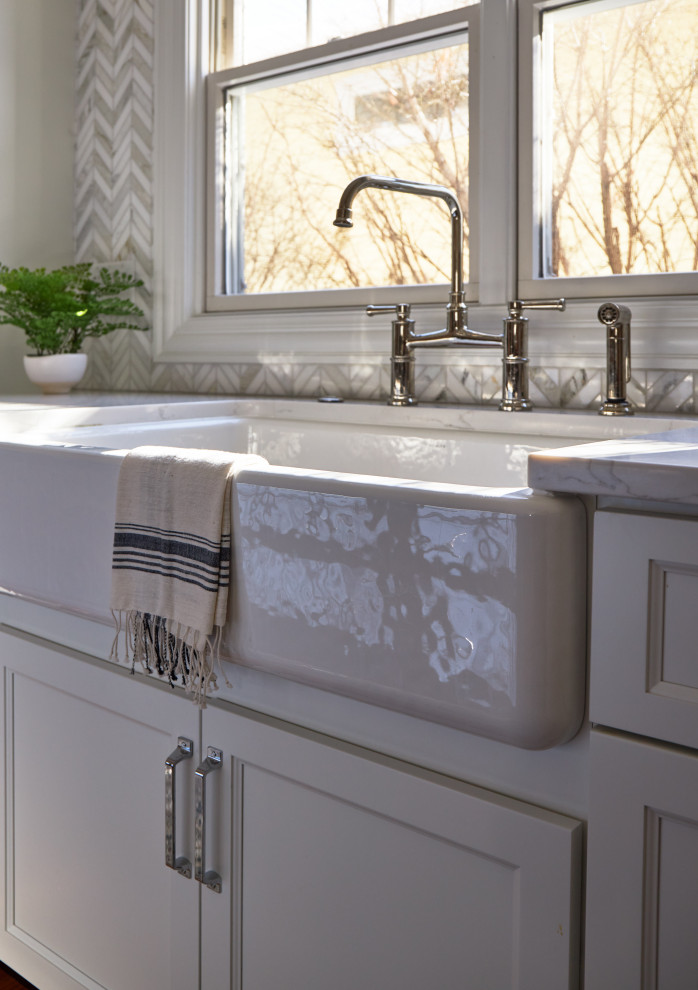 Eat-in kitchen - large transitional l-shaped medium tone wood floor and brown floor eat-in kitchen idea in Chicago with a farmhouse sink, shaker cabinets, white cabinets, quartz countertops, multicolored backsplash, marble backsplash, stainless steel appliances, an island and white countertops