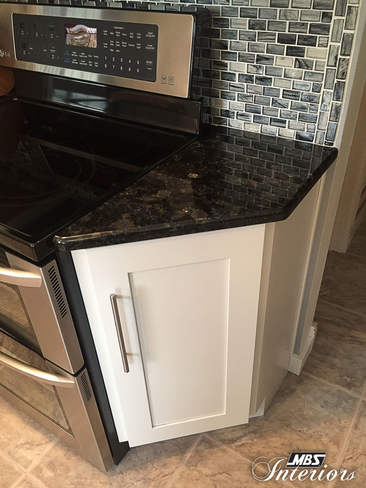 Inspiration for a mid-sized transitional galley ceramic tile and beige floor eat-in kitchen remodel with a farmhouse sink, white cabinets, stainless steel appliances, shaker cabinets, granite countertops, blue backsplash, glass sheet backsplash and an island