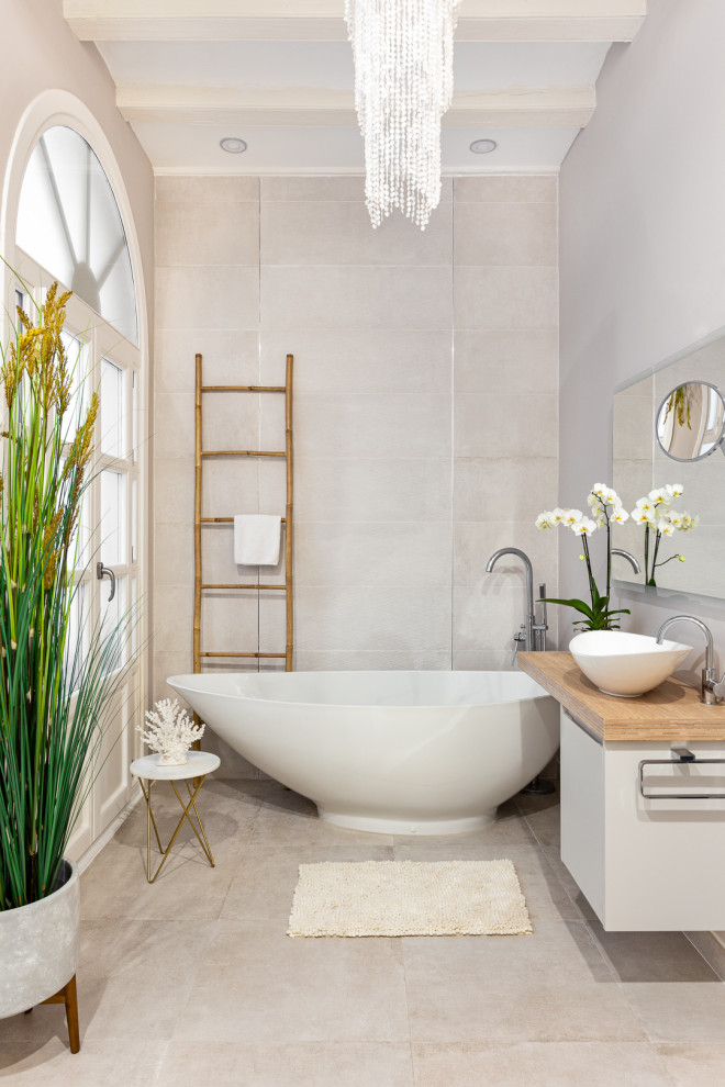 Inspiration for a contemporary bathroom in Barcelona with flat-panel cabinets, white cabinets, a freestanding tub, gray tile, grey walls, a vessel sink, wood benchtops, grey floor, beige benchtops, a single vanity, a floating vanity and exposed beam.