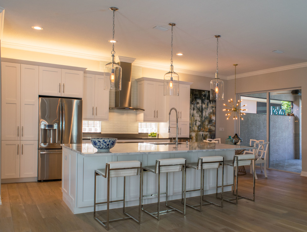 Open concept kitchen - mid-sized transitional single-wall light wood floor and beige floor open concept kitchen idea in Miami with shaker cabinets, white cabinets, marble countertops, white backsplash, stainless steel appliances, an island, an undermount sink and subway tile backsplash
