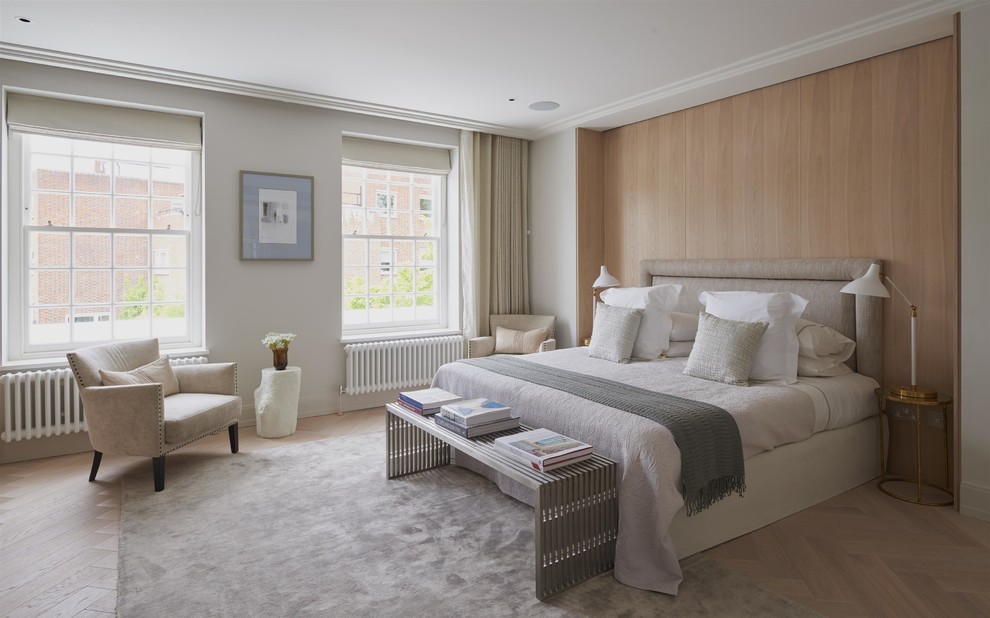 This is an example of a contemporary bedroom in London with white walls and light hardwood floors.