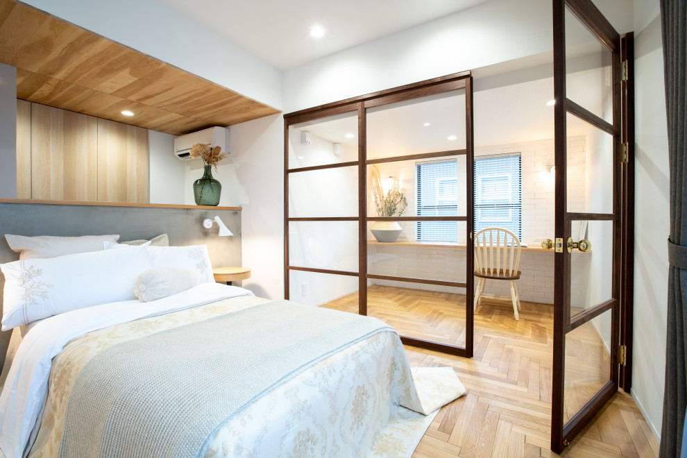 Ejemplo de dormitorio principal romántico sin chimenea con paredes blancas, suelo de madera en tonos medios, madera y papel pintado