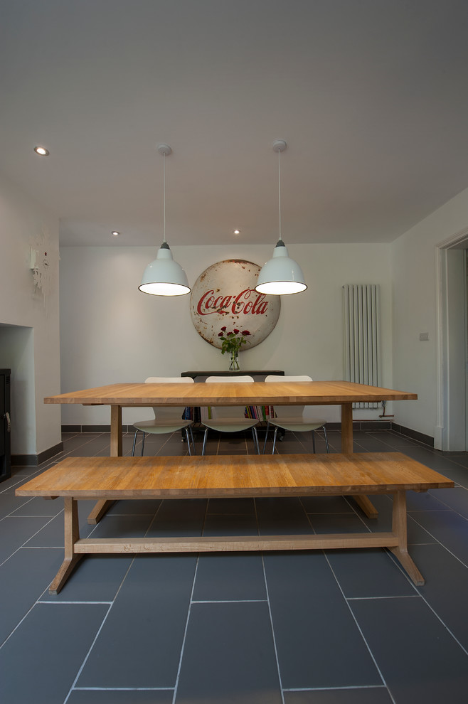 This is an example of an eclectic dining room in Gloucestershire with yellow walls and ceramic floors.