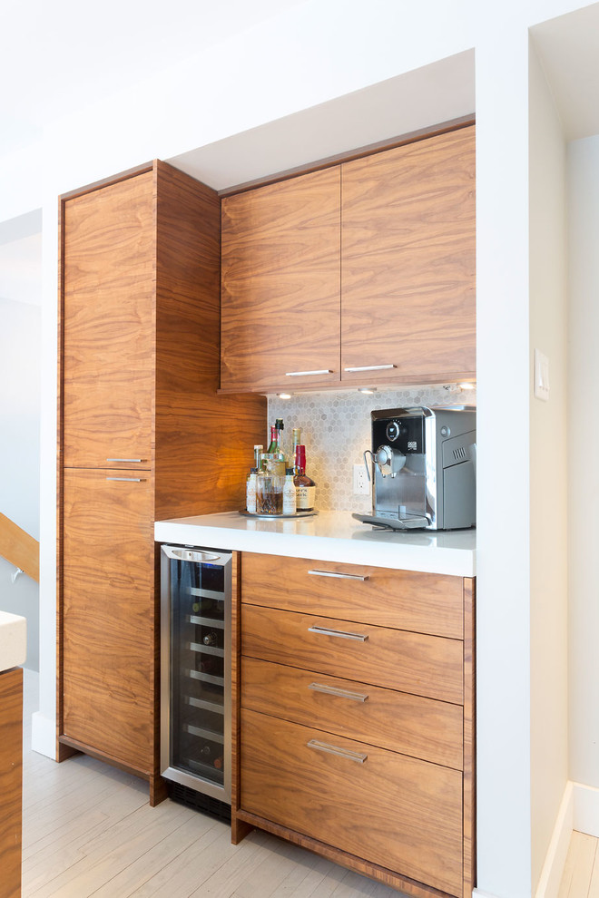 Photo of a mid-sized midcentury single-wall home bar in Other with an undermount sink, flat-panel cabinets, dark wood cabinets, quartzite benchtops, grey splashback, stone tile splashback and light hardwood floors.