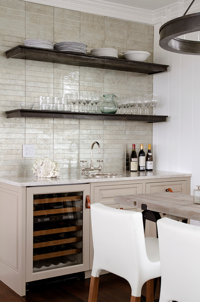 Beach style wet bar in New York with a drop-in sink, raised-panel cabinets and beige cabinets.