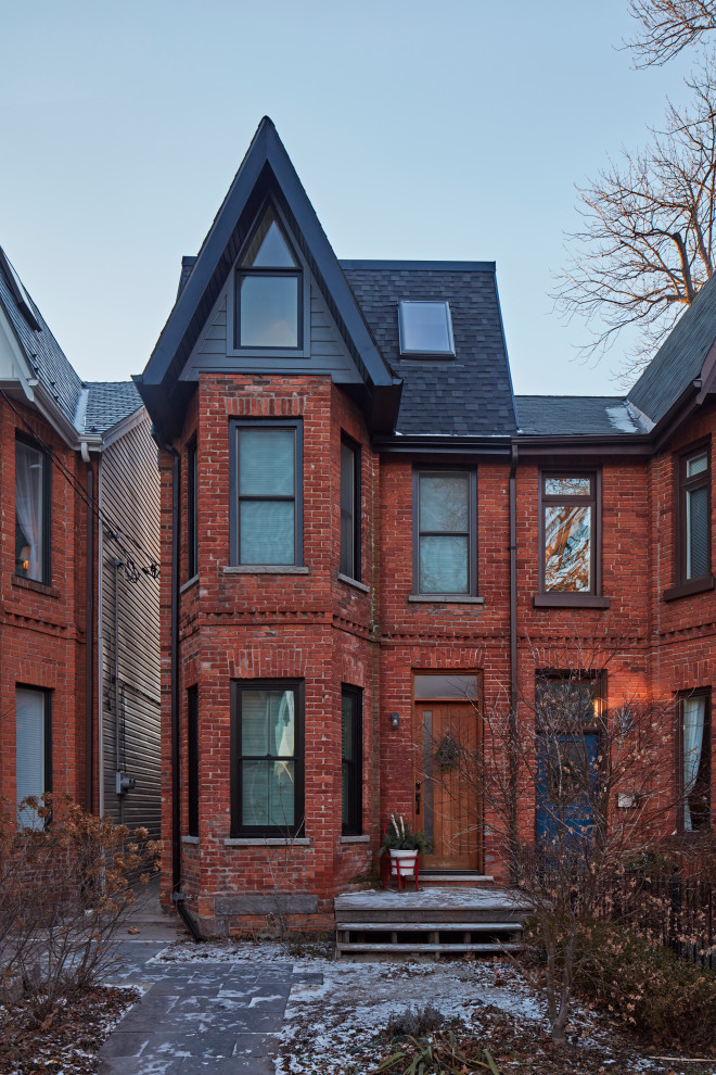Small scandinavian three-storey brick townhouse exterior in Toronto with a flat roof.
