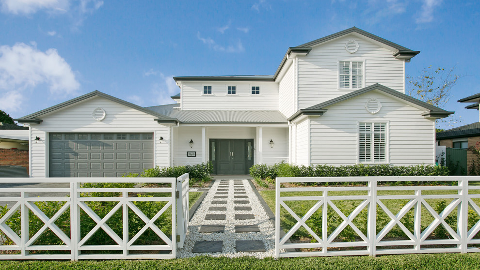 Photo of a country two-storey white house exterior in Gold Coast - Tweed with vinyl siding, a gable roof and a metal roof.