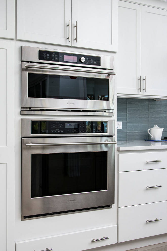 Example of a mid-sized transitional u-shaped porcelain tile and gray floor open concept kitchen design in Tampa with a double-bowl sink, recessed-panel cabinets, white cabinets, marble countertops, gray backsplash, cement tile backsplash, stainless steel appliances and an island
