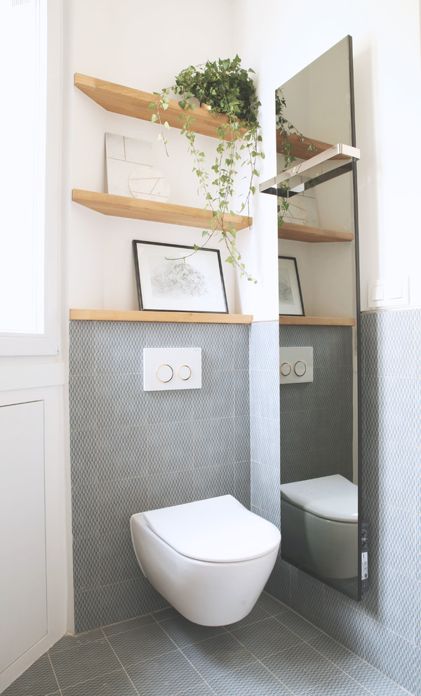 Design ideas for a scandinavian powder room in Paris with a wall-mount toilet, gray tile, white walls and grey floor.