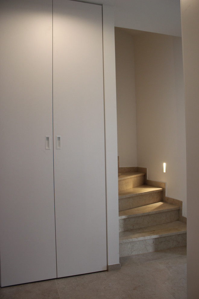 На фото: п-образная лестница среднего размера в современном стиле с ступенями из известняка и подступенками из известняка с