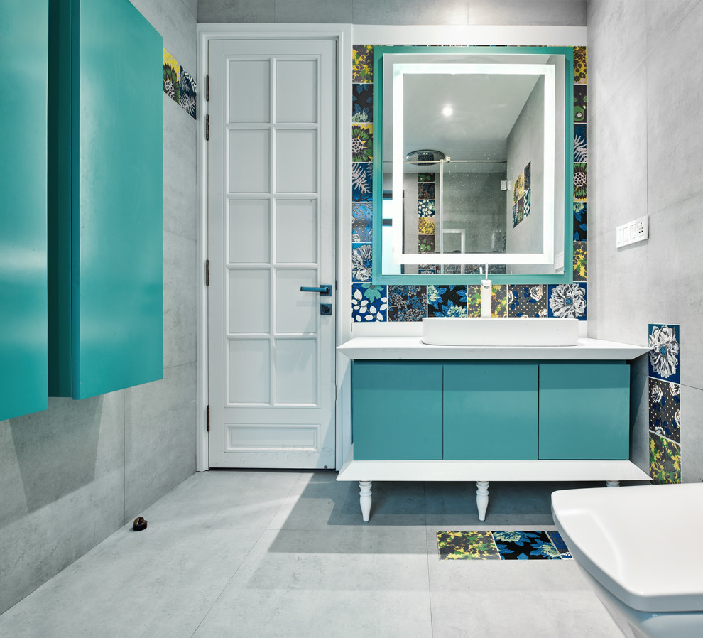 Inspiration for a mid-sized contemporary bathroom in Bengaluru with flat-panel cabinets, gray tile, grey walls, a vessel sink, grey floor, white benchtops and cement tile.