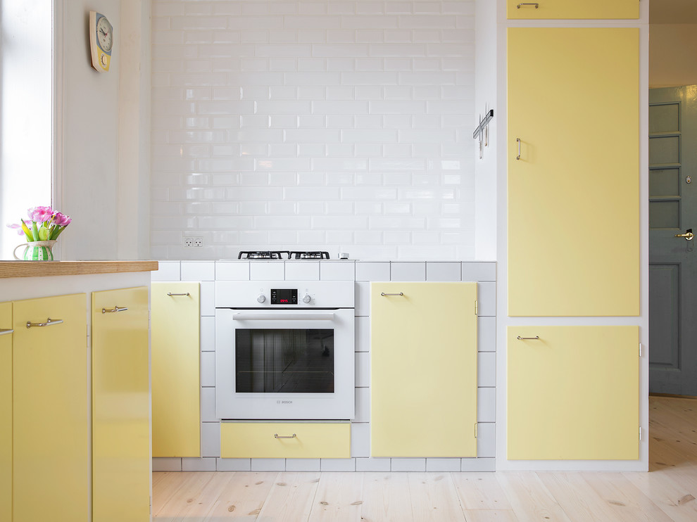 Design ideas for a scandinavian l-shaped kitchen in Copenhagen with yellow cabinets.