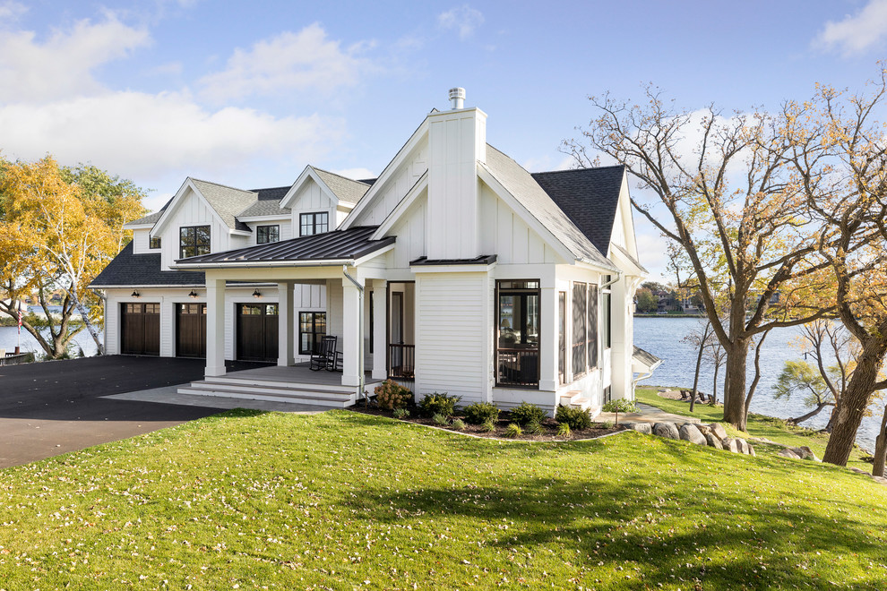 Beach style two-storey white house exterior in Minneapolis with a gable roof and a mixed roof.