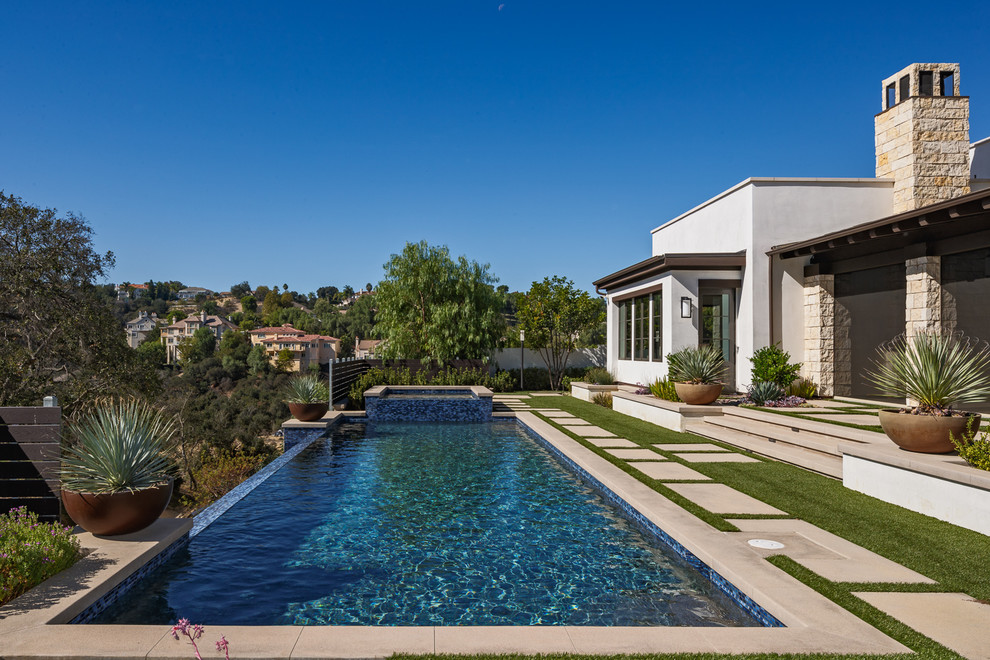 Design ideas for a mediterranean backyard rectangular infinity pool in Los Angeles with a hot tub.