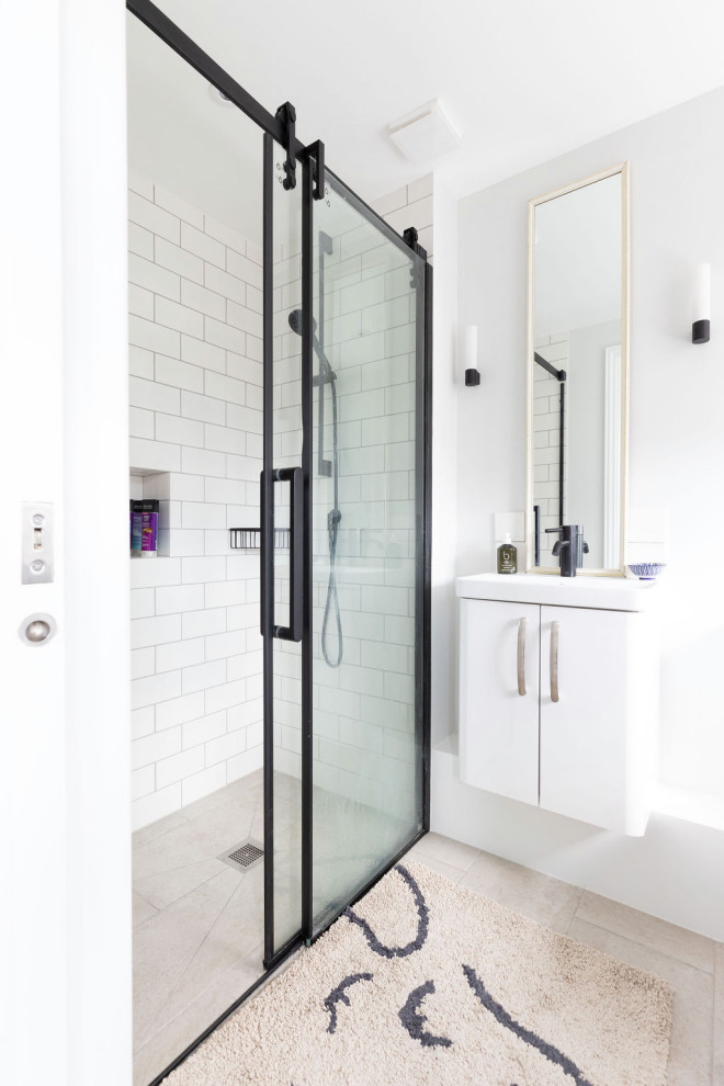 Design ideas for a small modern grey and black ensuite bathroom in London with a built-in shower, grey tiles, ceramic tiles, grey walls, a wall-mounted sink, brown floors, a sliding door and a built in vanity unit.