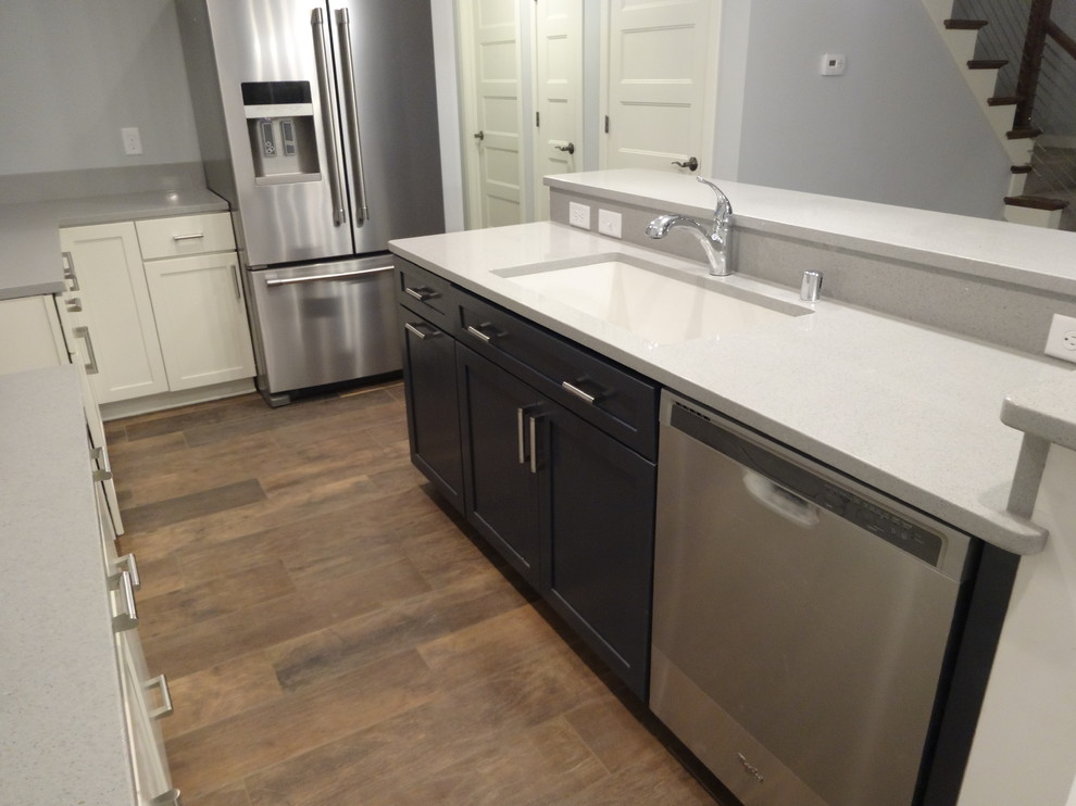 Inspiration for a mid-sized transitional l-shaped porcelain tile eat-in kitchen remodel in Milwaukee with a single-bowl sink, recessed-panel cabinets, white cabinets, quartz countertops, gray backsplash, stone slab backsplash, stainless steel appliances and an island