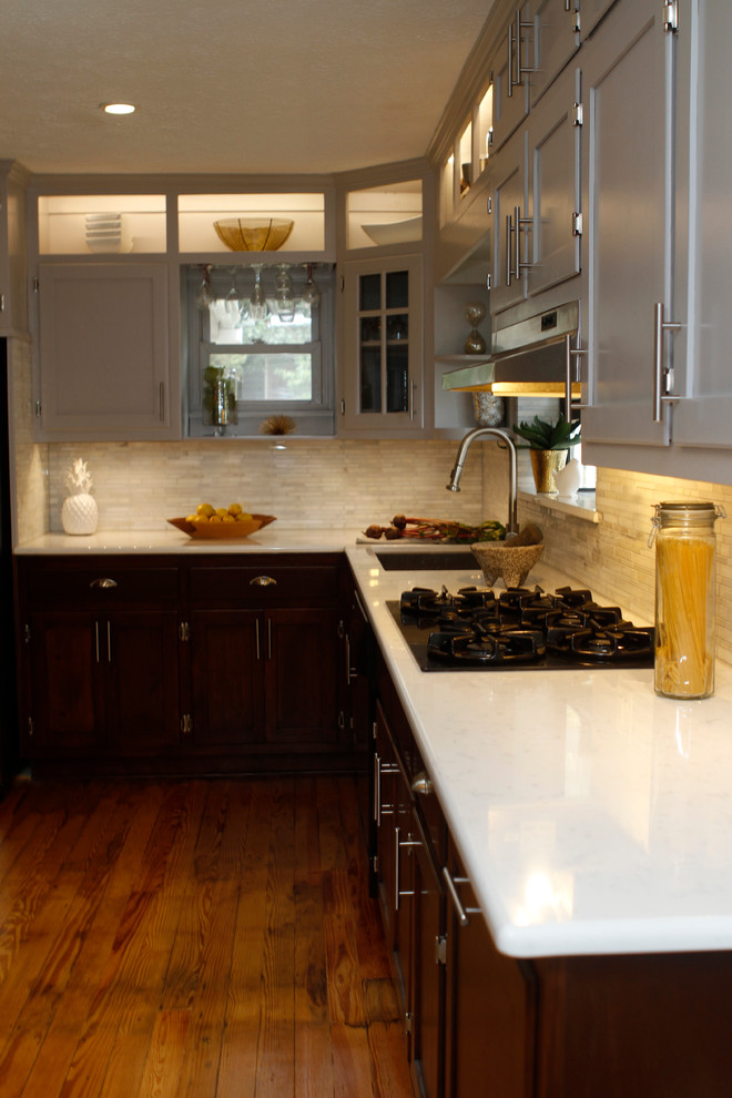 Mid-sized transitional u-shaped light wood floor enclosed kitchen photo in Atlanta with an undermount sink, recessed-panel cabinets, dark wood cabinets, quartz countertops, white backsplash, stone tile backsplash, stainless steel appliances and an island