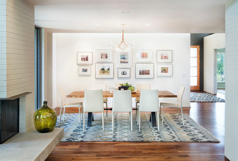 This is an example of a contemporary dining room in Austin with white walls and medium hardwood floors.
