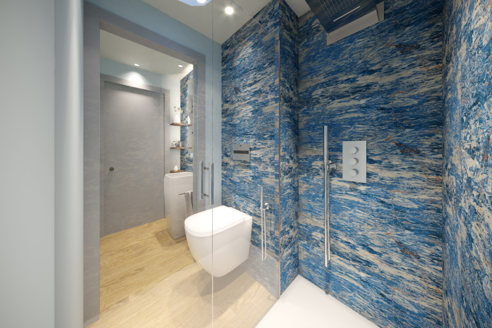 This is an example of a small modern powder room in Florence with a one-piece toilet, blue tile, porcelain tile, grey walls, medium hardwood floors, a pedestal sink, brown floor and recessed.