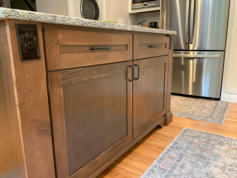 Inspiration for a mid-sized transitional l-shaped light wood floor and brown floor open concept kitchen remodel in DC Metro with a farmhouse sink, recessed-panel cabinets, white cabinets, granite countertops, gray backsplash, ceramic backsplash, stainless steel appliances, an island and multicolored countertops