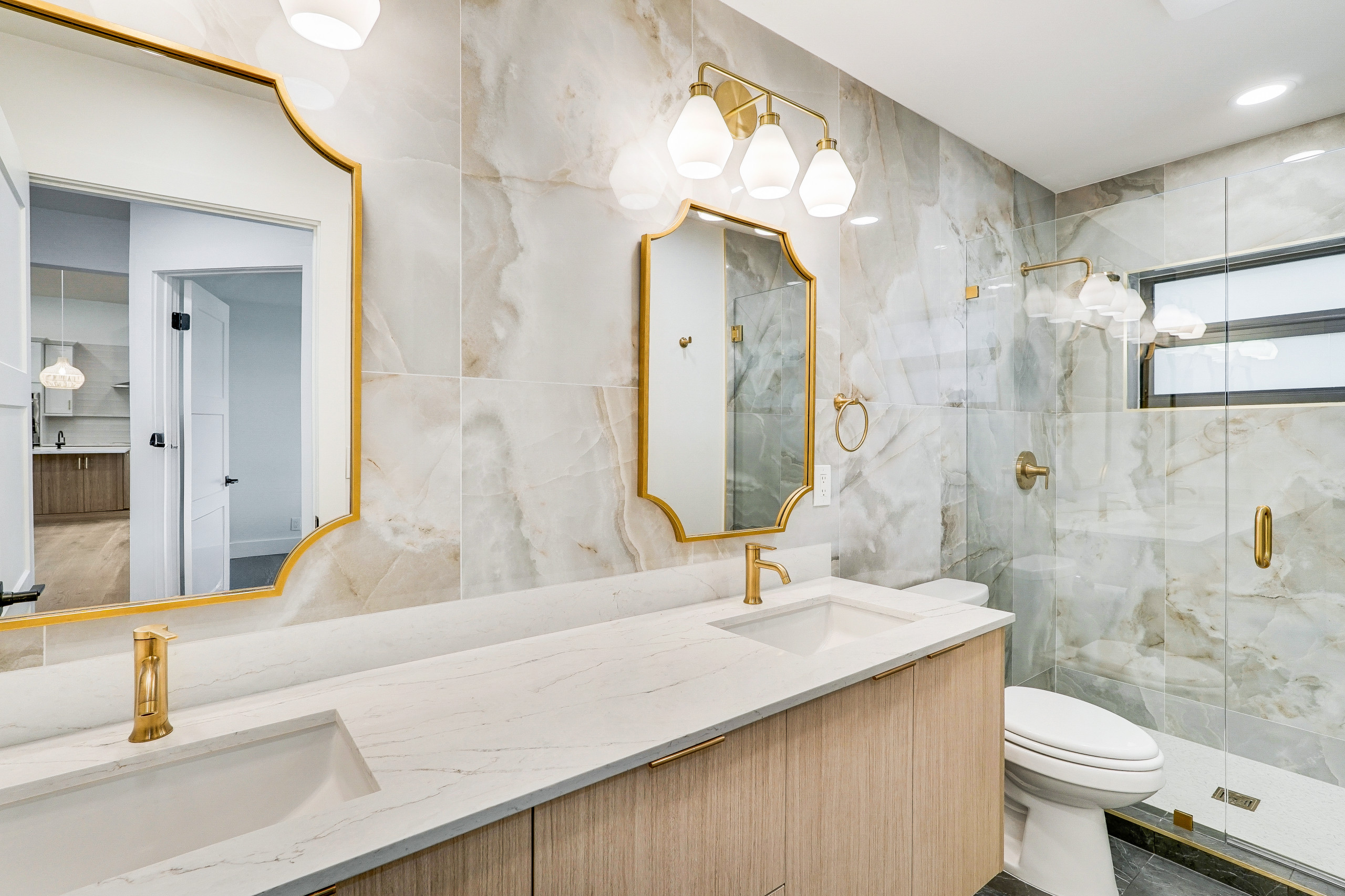 guest bath with large format tile back splash, ornate mirrors and floating vanity