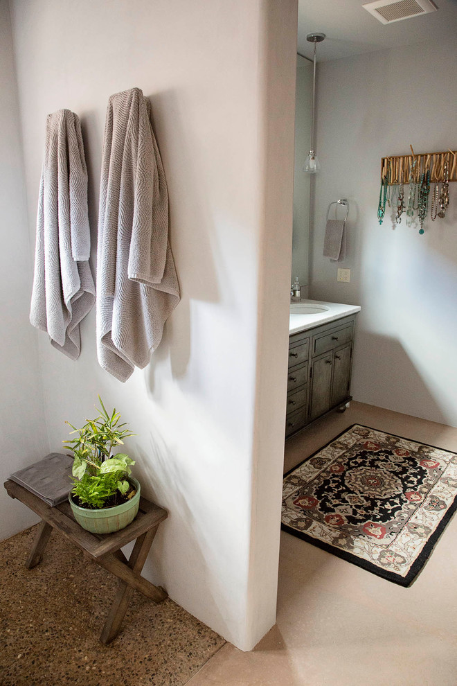 This is an example of a mid-sized contemporary 3/4 bathroom in Albuquerque with raised-panel cabinets, distressed cabinets, a corner tub, an open shower, a one-piece toilet, white tile, stone slab, beige walls, porcelain floors, a drop-in sink, solid surface benchtops, beige floor and an open shower.