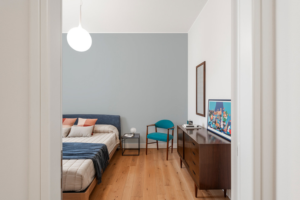 Esempio di una camera matrimoniale minimal di medie dimensioni con pareti blu, parquet chiaro e abbinamento di mobili antichi e moderni