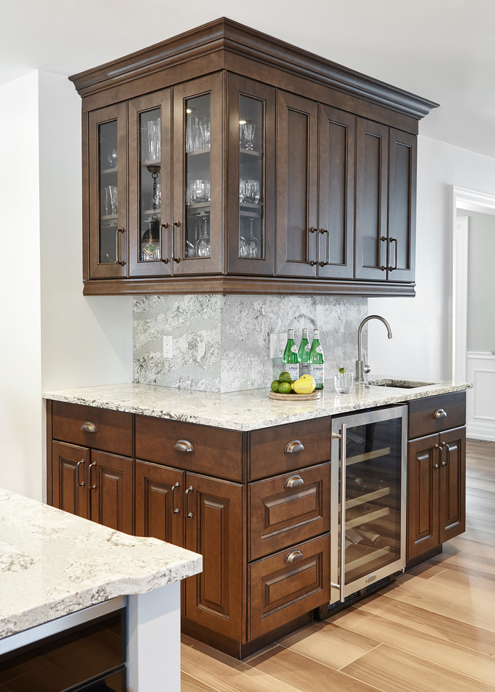 Large transitional l-shaped ceramic tile eat-in kitchen photo in Toronto with an undermount sink, raised-panel cabinets, dark wood cabinets, quartz countertops, gray backsplash, stone slab backsplash, paneled appliances and an island