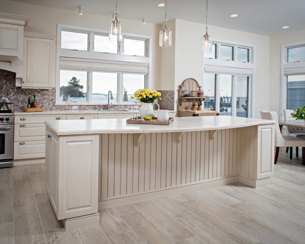 Inspiration for a transitional porcelain tile kitchen remodel with an undermount sink, solid surface countertops, stainless steel appliances and an island