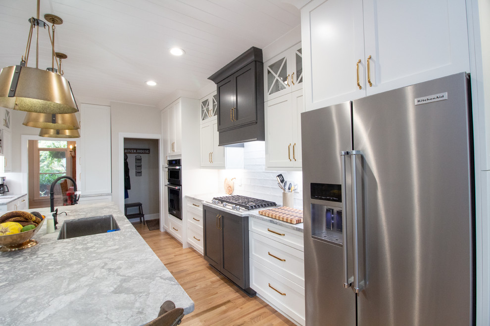 Eat-in kitchen - large l-shaped eat-in kitchen idea with shaker cabinets, white cabinets, granite countertops, an island and white countertops