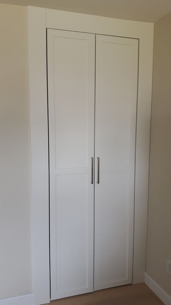 This is an example of a small traditional gender-neutral storage and wardrobe in Vancouver with white cabinets.