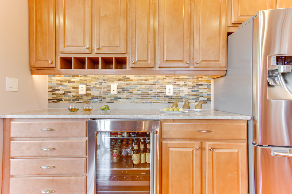 Kitchen - mid-sized transitional u-shaped medium tone wood floor kitchen idea in Baltimore with an undermount sink, raised-panel cabinets, medium tone wood cabinets, granite countertops, glass sheet backsplash, stainless steel appliances and an island