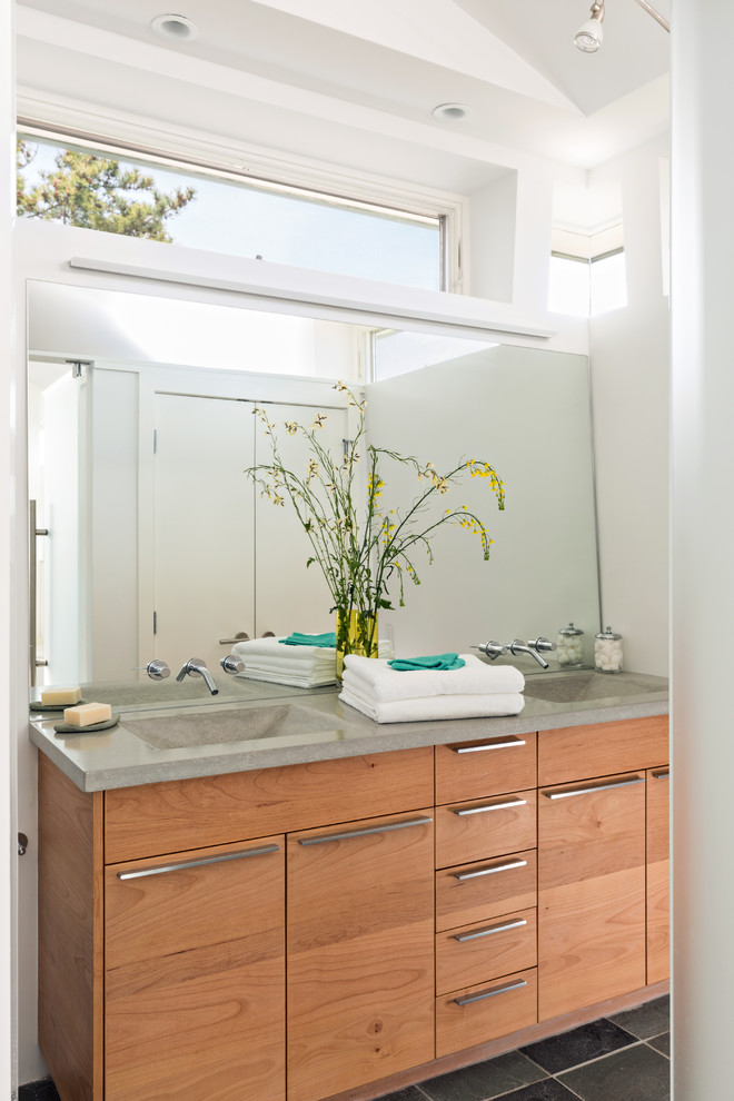 Beach style bathroom in Boston with flat-panel cabinets, medium wood cabinets, white walls and concrete benchtops.