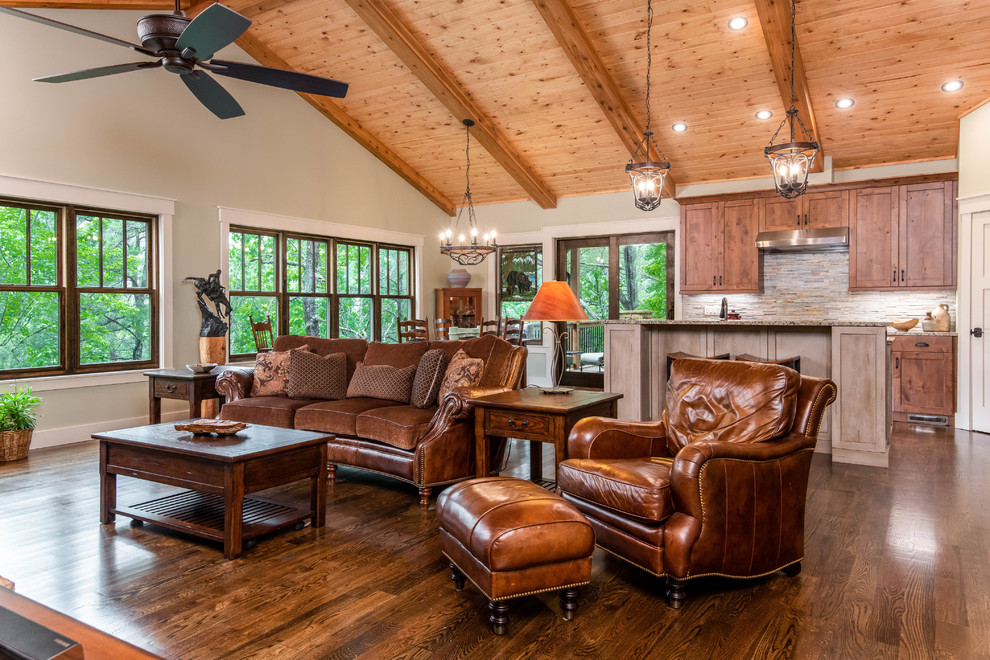 Mid-sized country formal open concept living room in Other with grey walls, medium hardwood floors, a standard fireplace, a stone fireplace surround, no tv and brown floor.