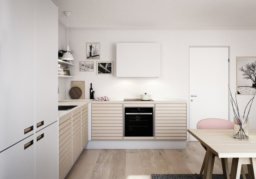 Inspiration for a mid-sized scandinavian l-shaped eat-in kitchen in Esbjerg with a drop-in sink, beaded inset cabinets, light wood cabinets, laminate benchtops, stainless steel appliances, light hardwood floors and no island.