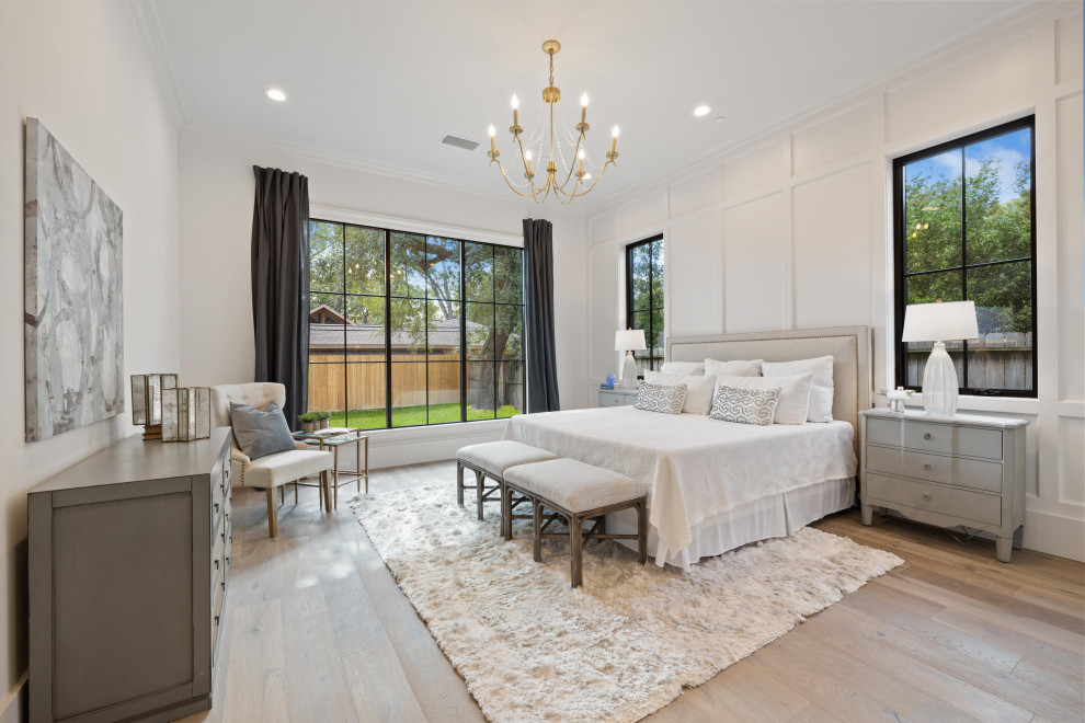This is an example of an expansive classic master bedroom in Houston with white walls, medium hardwood flooring, brown floors and panelled walls.