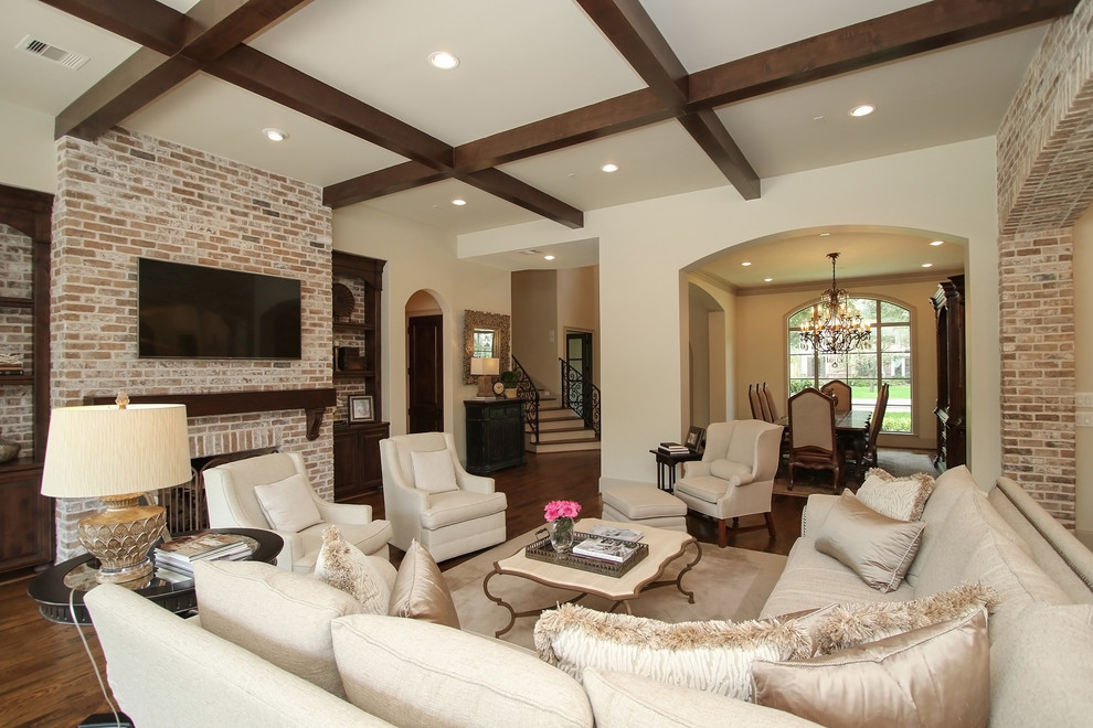 Design ideas for an expansive traditional open concept family room in Houston with dark hardwood floors, a standard fireplace, a brick fireplace surround, a wall-mounted tv and brown floor.