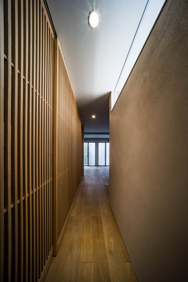 Cette image montre un petit couloir design avec un mur gris, un sol en bois brun, un plafond en papier peint et du papier peint.