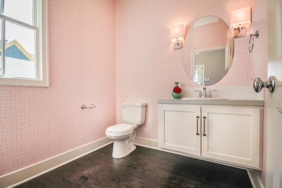Photo of a mid-sized transitional 3/4 bathroom in Other with shaker cabinets, white cabinets, a one-piece toilet, white tile, subway tile, pink walls, dark hardwood floors, a drop-in sink, quartzite benchtops and brown floor.