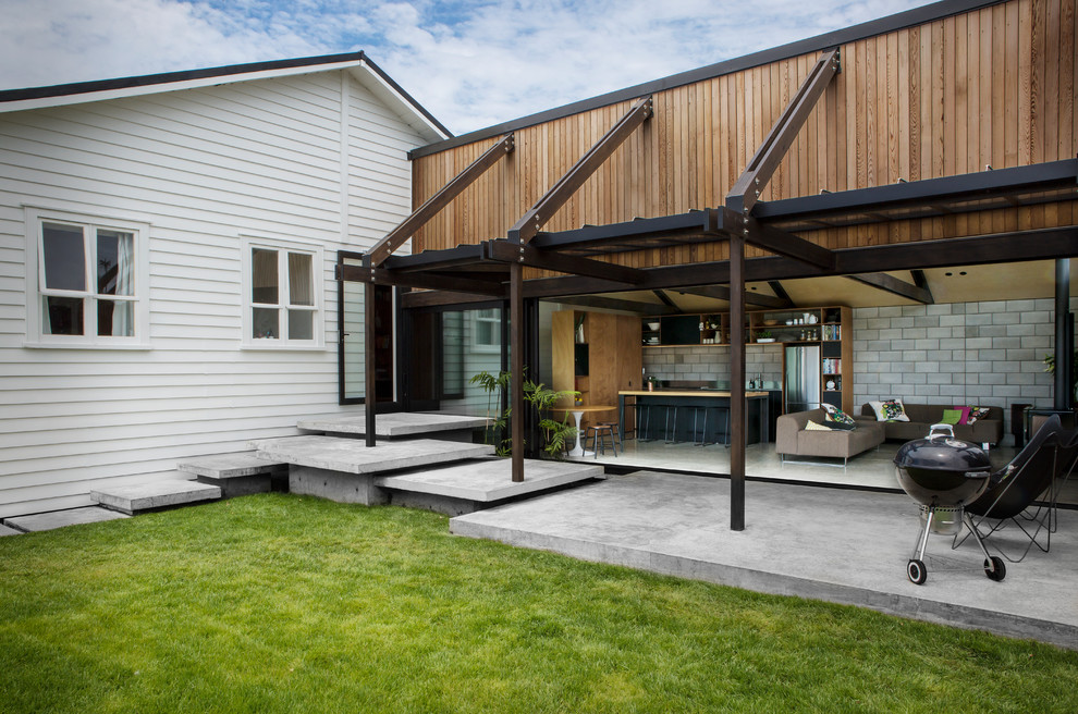 Industrial backyard patio in Auckland with concrete slab and an awning.
